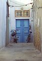 Picture Title - Blue door with  Motorped and bicycle