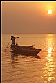 Picture Title - a boat a sunrise and a fisherman